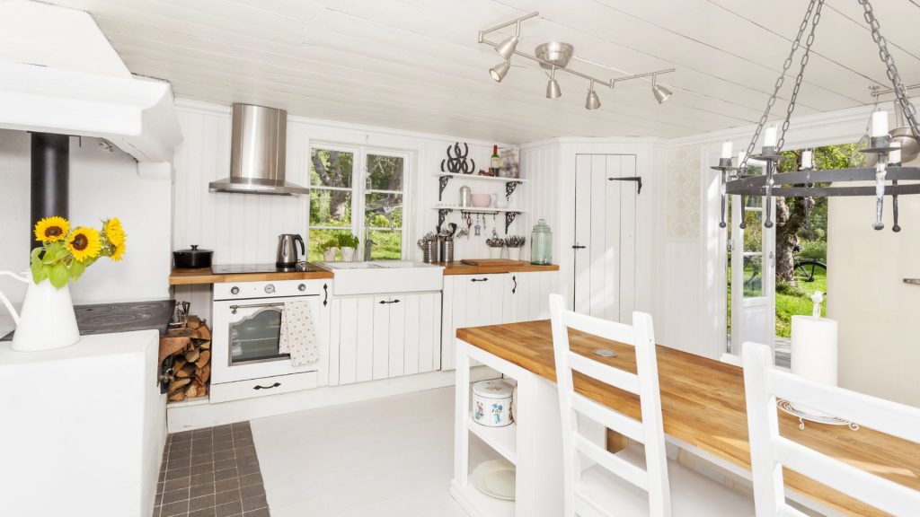 A kitchen with white cabinets and wooden counters.