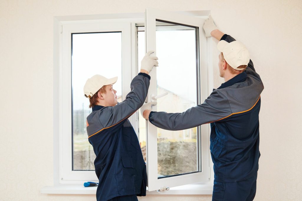 Two people are working on a window.