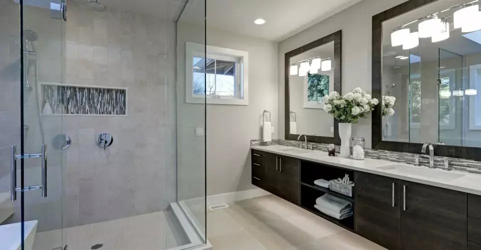 A bathroom with a glass shower door and white tile.